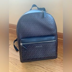 Michael Kors Debossed MK Monogram Backpack bag in brown and black - multi pocket